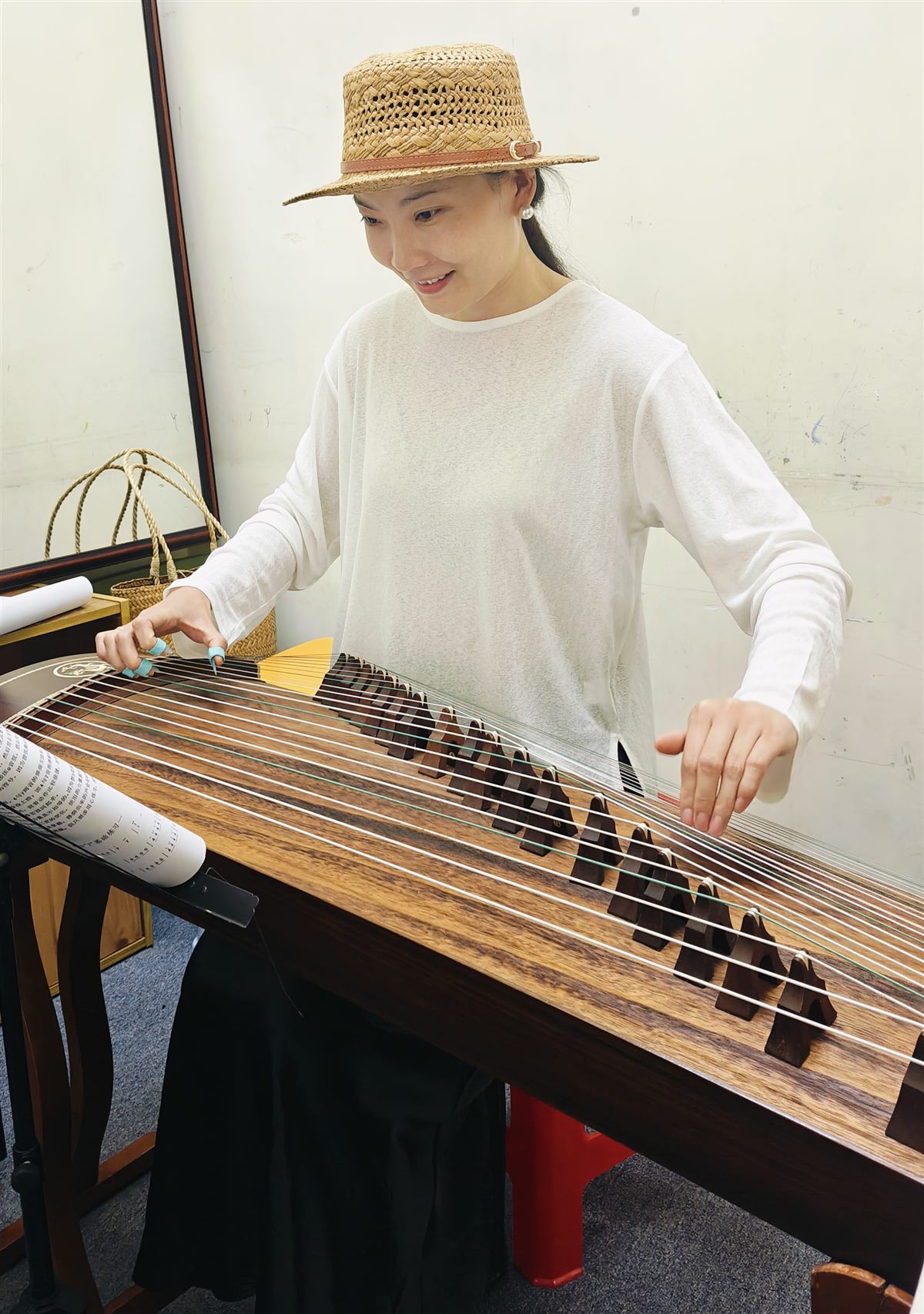 Teacher Lucky playing guzheng as part of Chinese cultural expression